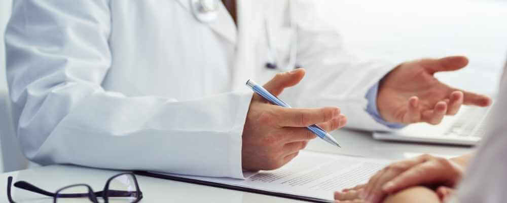 A surgeon talking to his patient about her hemorrhoid conditions